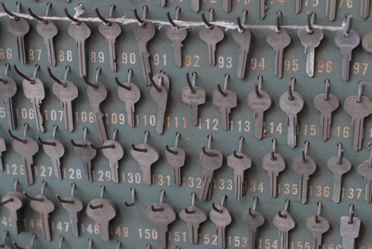 Many numbered keys hanging on a wall board.