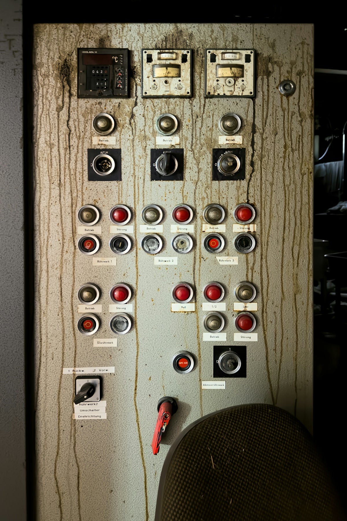 Old industrial control panel with gauges and buttons.