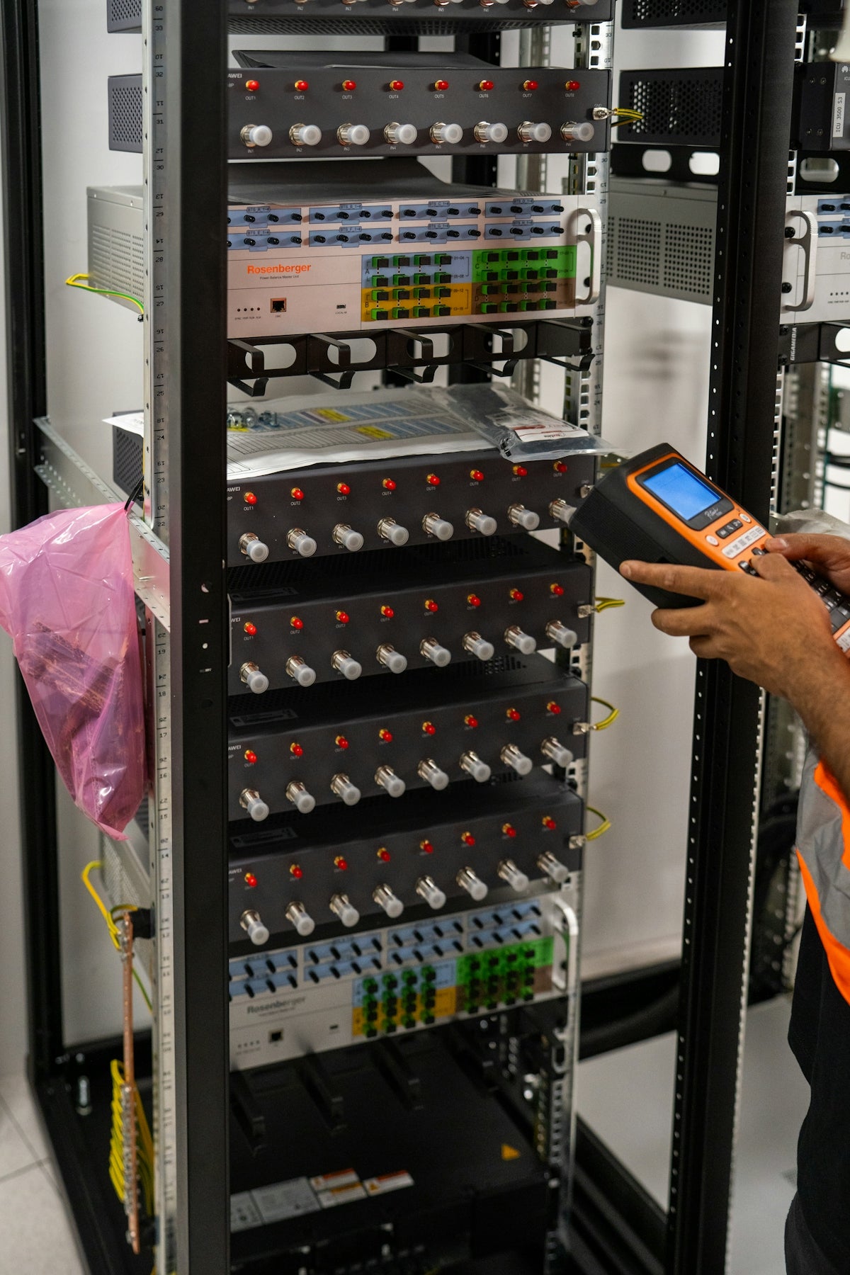 A technician works on a server rack with electronic equipment